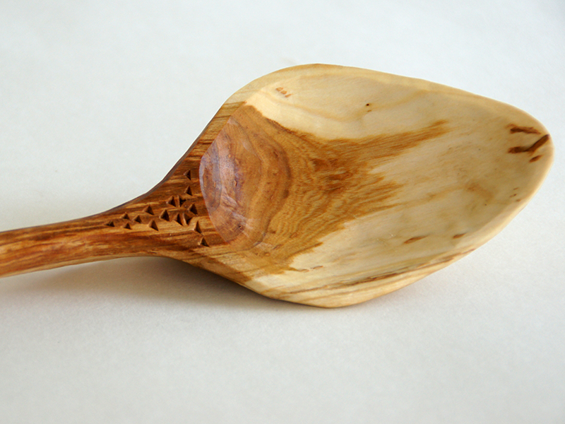 detail, chip-carved ladle of cherry wood