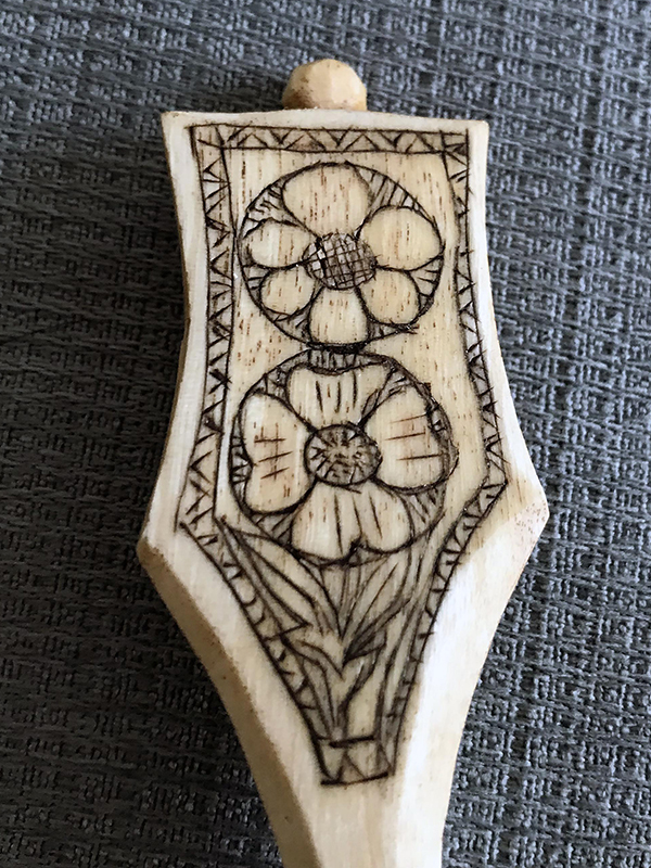 close-up of wooden spoon, handle decoation is kolrosed flowers
