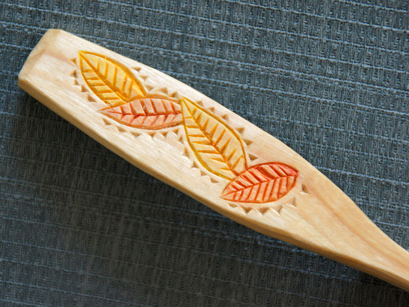 detail of wooden spoon, chipcarved and painted.
